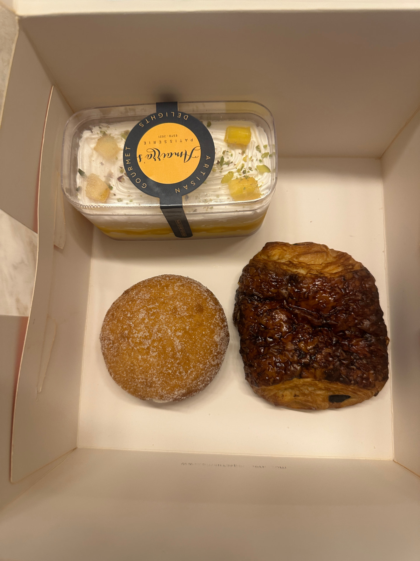 A Dusk Box packed with a mango custard tub, doughnut and pain au chocolat